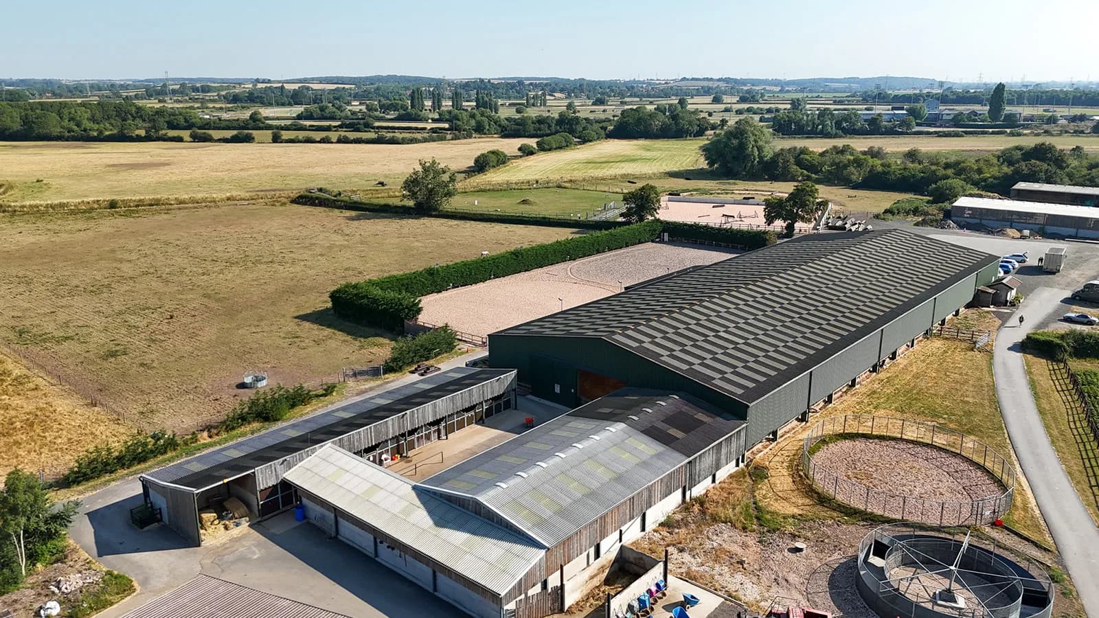 High aerial drone view of the full Trentvalley Equestrian Centre site with open countryside and farmland in all directions