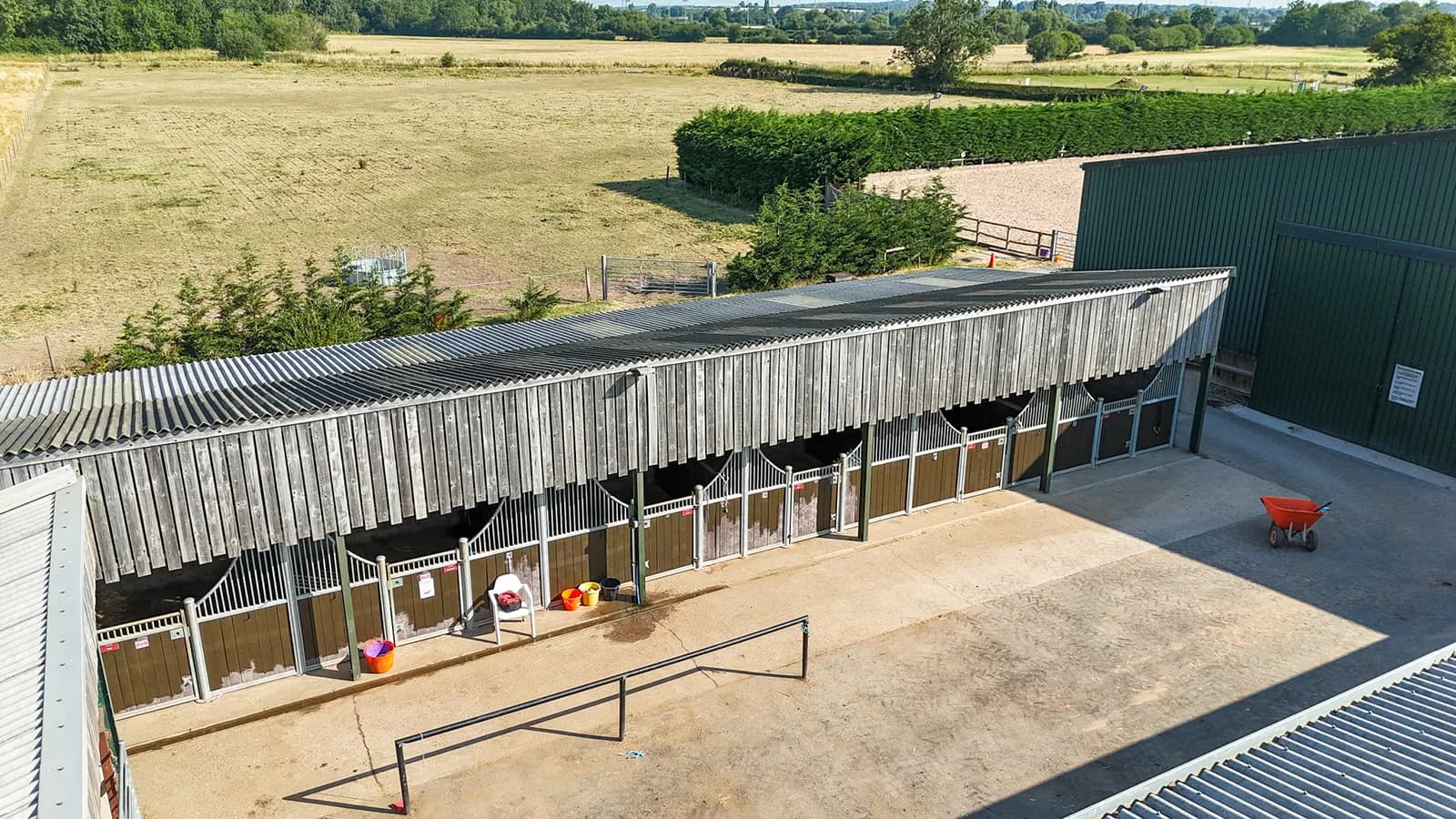 Aerial drone view of the open-sided stable block with individual stalls at Trentvalley Equestrian Centre